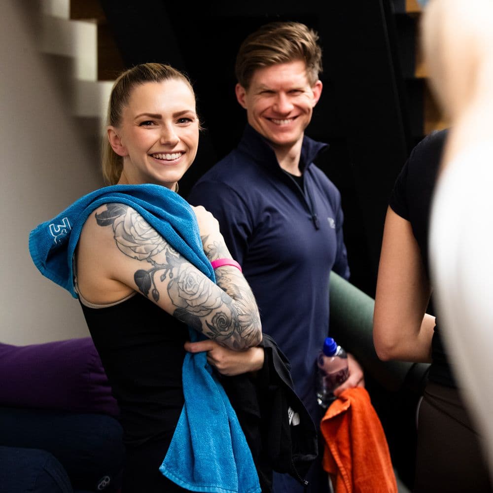 Dame og mann på trening som smiler til kamera